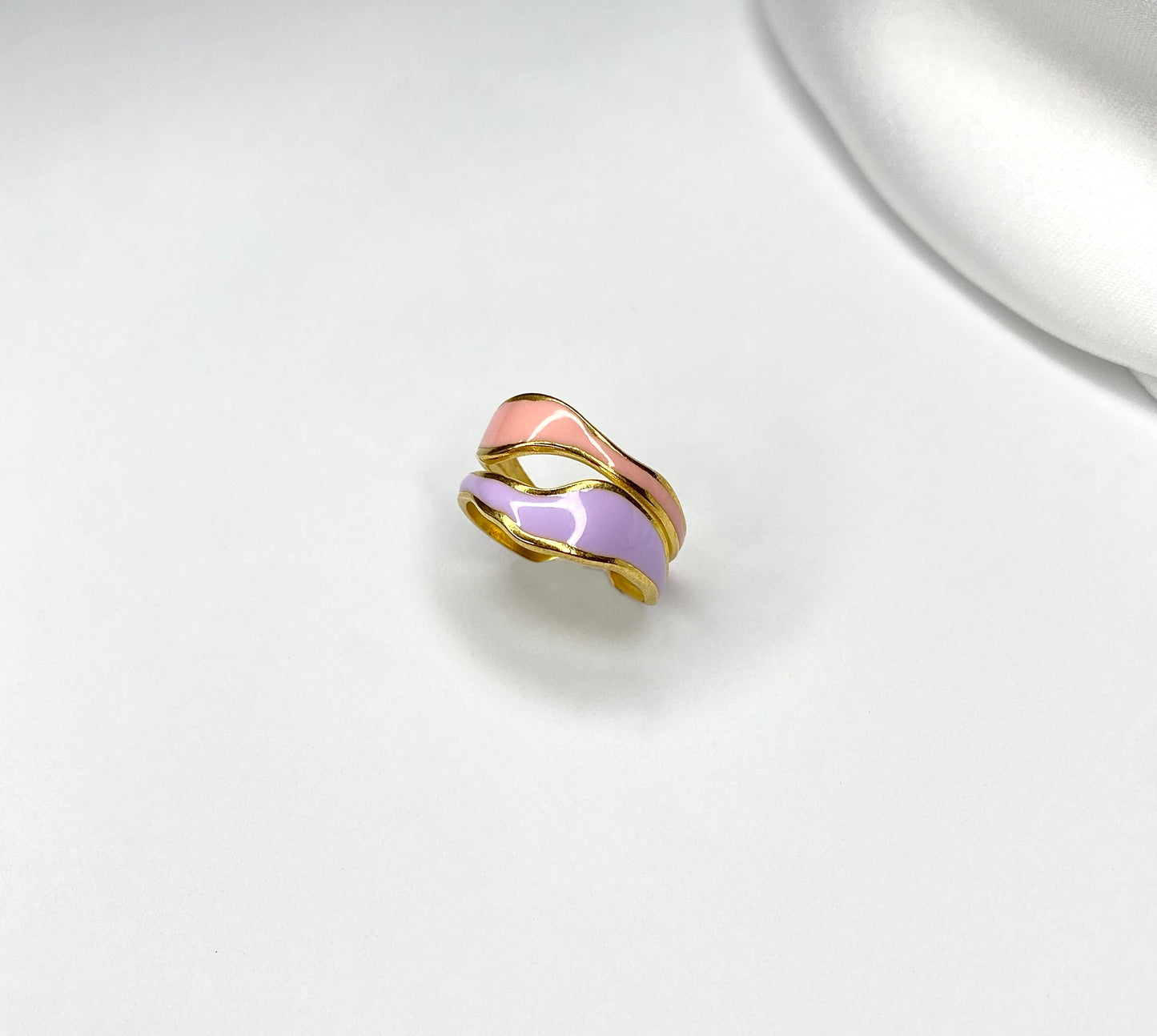 Anello IrìAnello dalla forma ad onde irregolari, composto da doppio colore: pesca e lilla smaltato. In acciaio inossidabile, placcato in oro 14k, anallergico.
GUIDA ALLE TAGLIAnello IrìAnelli